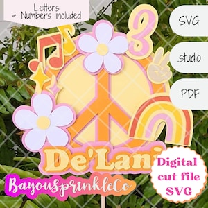 May include: A vibrant cake topper featuring a peace symbol, flowers, musical notes, and a rainbow. The topper includes the name "De'Lani" and the text "Letters + Numbers included". The design uses yellow, orange, pink, and white.