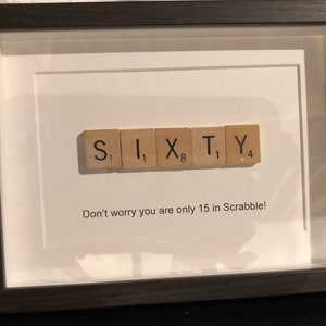 May include: A framed image with the word "SIXTY" spelled out using Scrabble tiles. The tiles are arranged in a row and the number value of each tile is shown below the letter. The caption below the tiles reads "Don't worry you are only 15 in Scrabble!"
