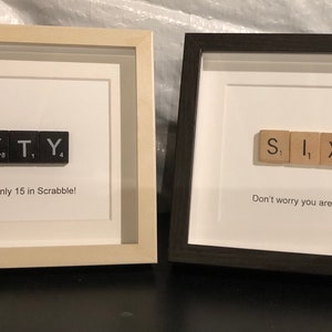 May include: Two framed pieces of art with the word "SIXTY" spelled out using Scrabble tiles. The text below the tiles reads "Don't worry you are only 15 in Scrabble!"