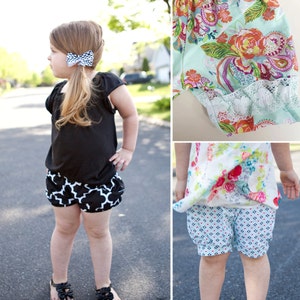 May include: Two girls wearing different styles of shorts. One girl is wearing black and white checkered shorts with a black shirt. The other girl is wearing blue and white patterned shorts with a floral top.