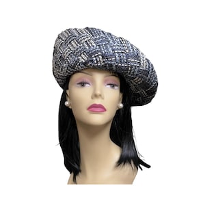 May include: A blue and white woven hat with a wide brim. The hat is sitting on a mannequin's head.