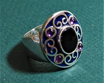 A silver ring with an Onyx, Amethysts and enamel