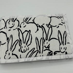 May include: A white fabric pouch with a black and white rabbit print. The pouch has a white border around the edges.