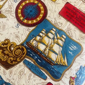 May include: Cream-colored fabric with a nautical map design. Features a compass rose, sailing ship, and text labels like "MALABAR" and "PRACTICAL NAVIGATION." The map includes islands, coastlines, and navigational elements.