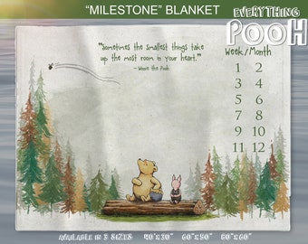 Könnte beinhalten: Eine Winnie Puuh-Milestone-Decke mit einer Aquarell-Illustration von Puuh und Ferkel in einer Waldlandschaft. Die Decke enthält ein Zitat von Winnie Puuh: "Manchmal nehmen die kleinsten Dinge den meisten Platz in deinem Herzen ein." Die Decke ist in drei Größen erhältlich: 40x30 Zoll, 60x50 Zoll und 80x60 Zoll.
