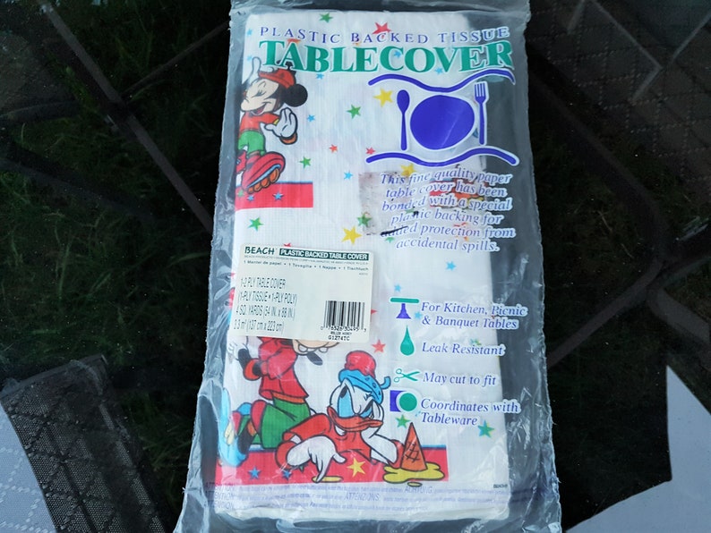 以下が含まれることがあります： 透明なプラスチックパッケージに入った、プラスチック裏打ちのティッシュテーブルクロス。テーブルクロスには、漫画のキャラクター、ミッキーマウスとドナルドダックが描かれています。パッケージには「Plastic Backed Tissue Tablecover」と書かれています。テーブルクロスの幅は137cmです。