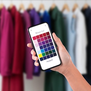 May include: A black smartphone displaying a Winter Cool colour palette grid on its screen. The interface features a header with the text Winter Cool, a grid of various coloured squares, and the brand name Chromeria at the bottom right corner.