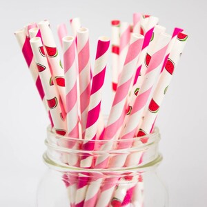 May include: A glass jar filled with pink and white striped paper straws with a watermelon print. The jar is labeled "Bernardin".
