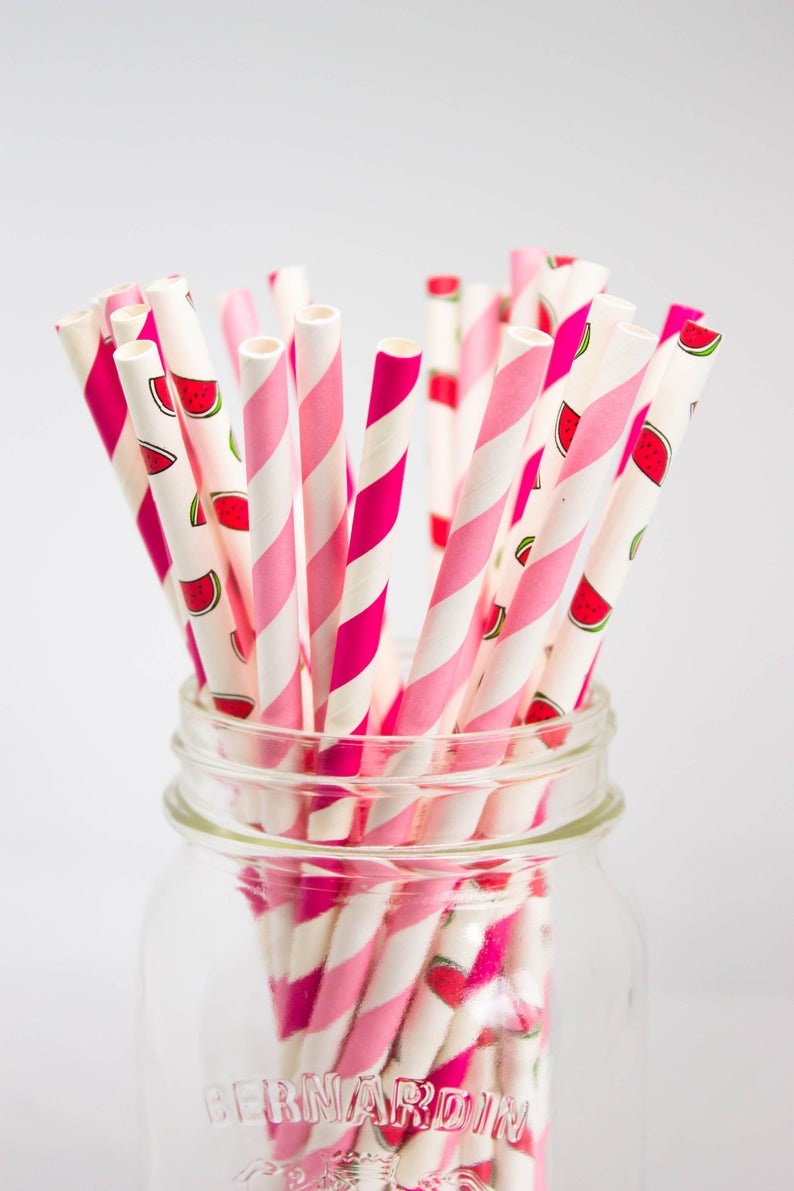 May include: A glass jar filled with pink and white striped paper straws with a watermelon print. The jar is labeled "Bernardin".