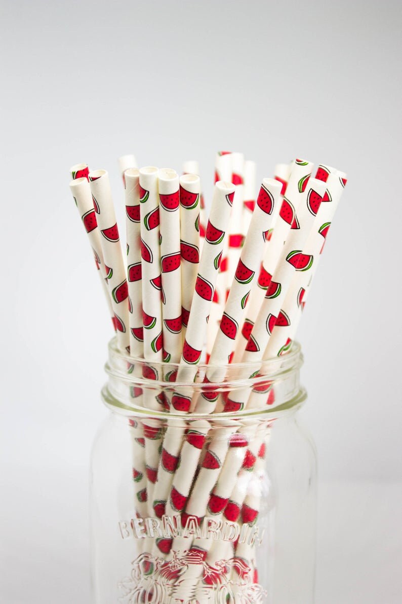 May include: A glass jar filled with white paper straws with a red watermelon pattern. The jar is labeled "Bernardin".