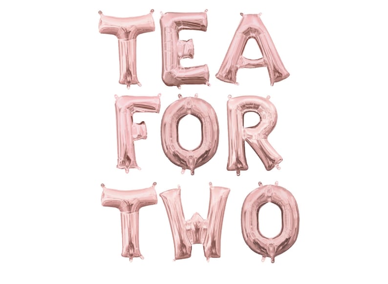 May include: Rose gold foil letter balloons spelling out "TEA FOR TWO".