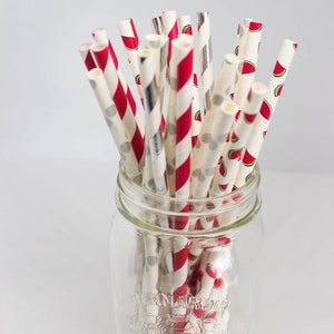 May include: A glass jar filled with red and white striped paper straws with watermelon print. The jar has the text "Bernardin" on the side.