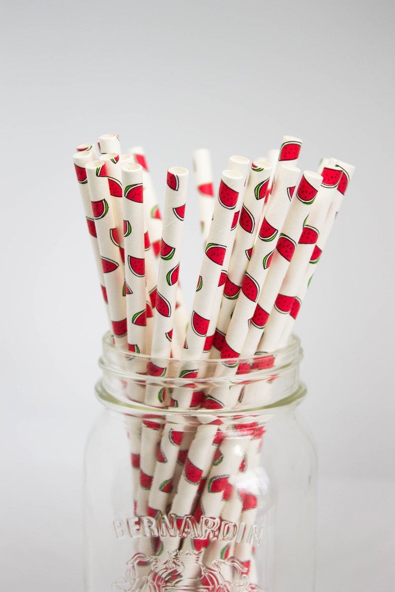 May include: A glass jar filled with white paper straws with a watermelon print. The jar is labeled "Bernardin".