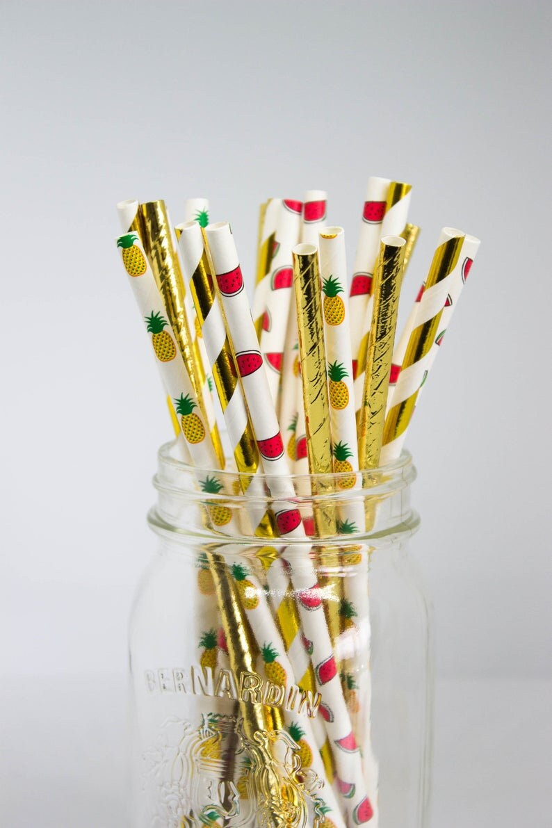 May include: A glass jar filled with a variety of gold and white striped paper straws with a pineapple and watermelon pattern. The jar is labeled "Bernardin".