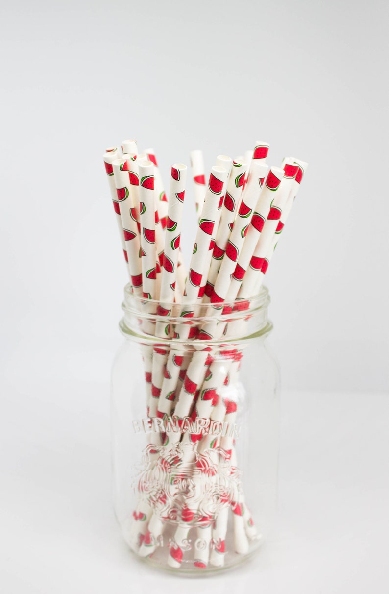 May include: A glass jar filled with white paper straws with a watermelon print. The jar is labeled "Bernardin Mason".