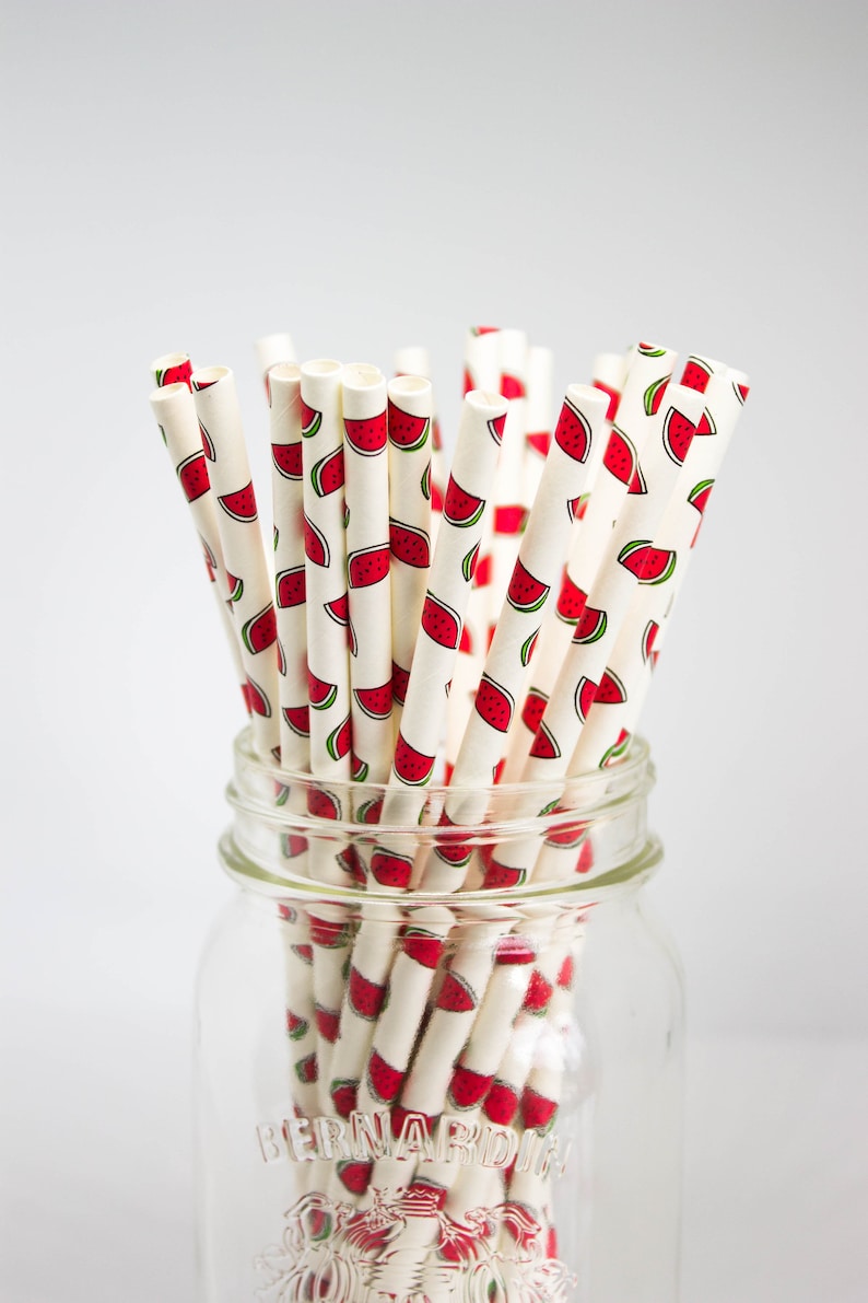 May include: A glass jar filled with white paper straws with a watermelon print. The jar has the word "BERNARDIN" printed on the side.