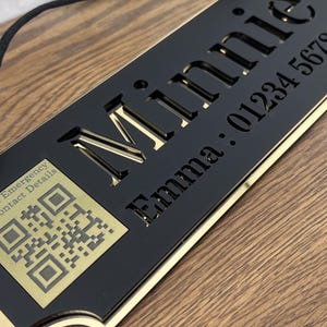 May include: Black and gold pet tag with the name "Minnie" and a phone number. The tag includes a QR code and the text "Scan in Emergency For Contact Details."