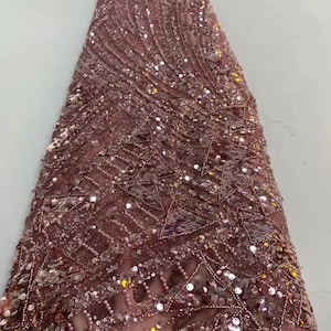 Puede incluir: Tela rosa con lentejuelas con un patrón geométrico. La tela está hecha de una malla transparente con lentejuelas y cuentas.