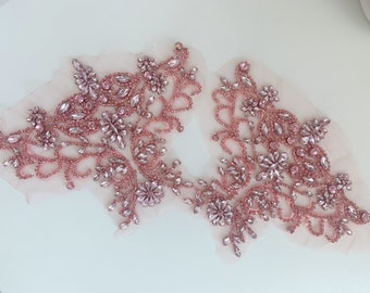 Könnte beinhalten: Zwei zarte rosa Perlenapplikationen mit Kristallverzierungen. Die Applikationen sind perfekt, um Kleidung, Accessoires oder Wohnaccessoires einen Hauch von Glanz zu verleihen.