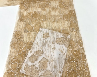 May include: Beige beaded lace fabric with a floral pattern. The fabric is sheer and has a delicate texture.