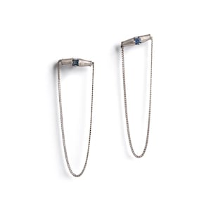 Könnte beinhalten: Ein Paar silberne Ohrringe mit einem blauen Edelstein und einer zarten Kette.