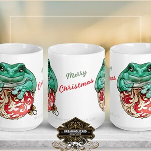 Puede incluir: Taza de cerámica blanca con una rana verde sentada en una bola de Navidad roja y dorada. La taza tiene el texto "Feliz Navidad".