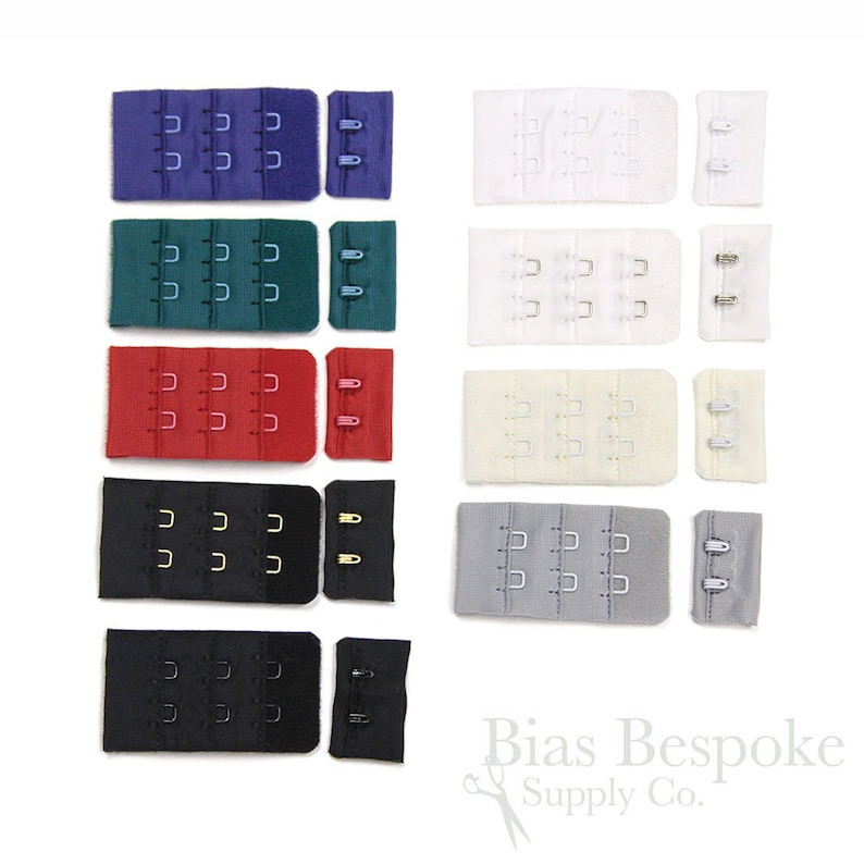 May include: A collection of ten bra extender sets in various colors including purple, teal, red, black, white, cream, and gray. Each set features three rows of hooks and eyes on a fabric base. The text Bias Bespoke Supply Co. is visible.