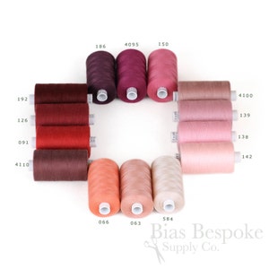 May include: A selection of 12 spools of thread in various shades of red, pink, and orange. The spools are arranged in a circle with the numbers 186, 4095, 150, 4100, 139, 138, 142, 584, 066, 063, 192, 126, 091, and 4110 printed on the labels. The text "Bias Bespoke Supply Co." is printed below the spools.