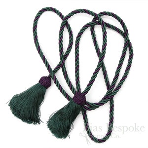 May include: A pair of green and purple tassel tiebacks with a twisted rope design.