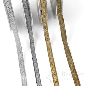 Könnte beinhalten: Drei Spulen mit metallischem Besatz mit geflochtenem Muster. Der Besatz ist silber, schwarz und gold.