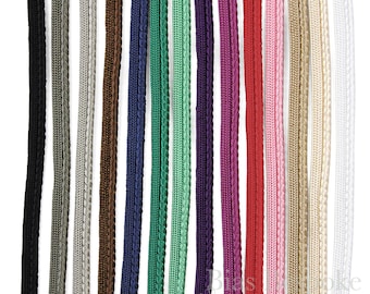 Könnte beinhalten: Sortiment aus 12 Farben geflochtener Schnur, darunter Schwarz, Grau, Weiß, Braun, Marineblau, Grün, Mint, Lila, Rosa, Rot, Beige und Creme.