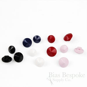 May include: A collection of various colored buttons, including black, navy blue, red, white, and pink. The buttons have a faceted, conical design. The image includes the text "Bias Bespoke Supply Co."