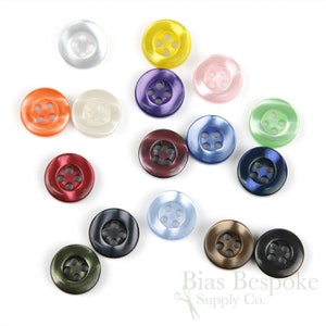 May include: Assortment of 14 four-hole plastic buttons in various colors, including red, blue, green, purple, orange, brown, black, white, and light blue.