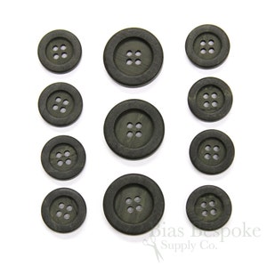 May include: A set of ten dark green buttons with four holes each. The buttons are made of a textured material and have a slightly raised edge.