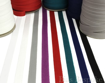 May include: A selection of 10 spools of bias binding in various colors, including white, gray, purple, red, teal, navy, and black. The spools are arranged in a row on a white surface. Bias Bespoke Supply Co. is printed on the surface.