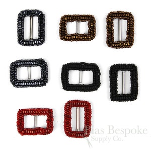 May include: Nine beaded buckle closures in various colors, including black, gray, brown, red, and gold. The buckles are rectangular and have a metal slider.
