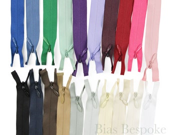 Può includere: Assortimento di 20 nastri per cerniere lampo in vari colori, tra cui blu navy, marrone, beige, verde chiaro, viola, lavanda, granata, rosso e rosa. Le cerniere lampo sono tutte chiuse e disposte in due file.