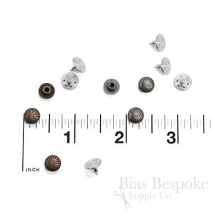 Könnte beinhalten: Sortiment aus Metallnieten in Silber- und Kupfertönen. Die Nieten werden auf einer weißen Oberfläche mit einem Lineal zur Skalierung gezeigt. Das Lineal zeigt die Maße in Zoll.