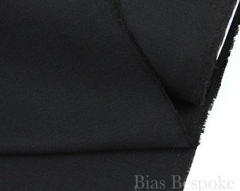May include: Black fabric with a subtle texture. The fabric is folded in half and the edges are visible. The fabric is labeled "Bias Bespoke Supply Co."