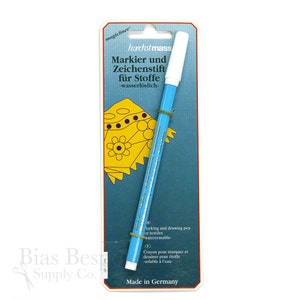 May include: A blue and white water-soluble marking and drawing pen for fabrics. The packaging features the text "Markier und Zeichenstift für Stoffe -wasserlöslich-." and "Made in Germany".