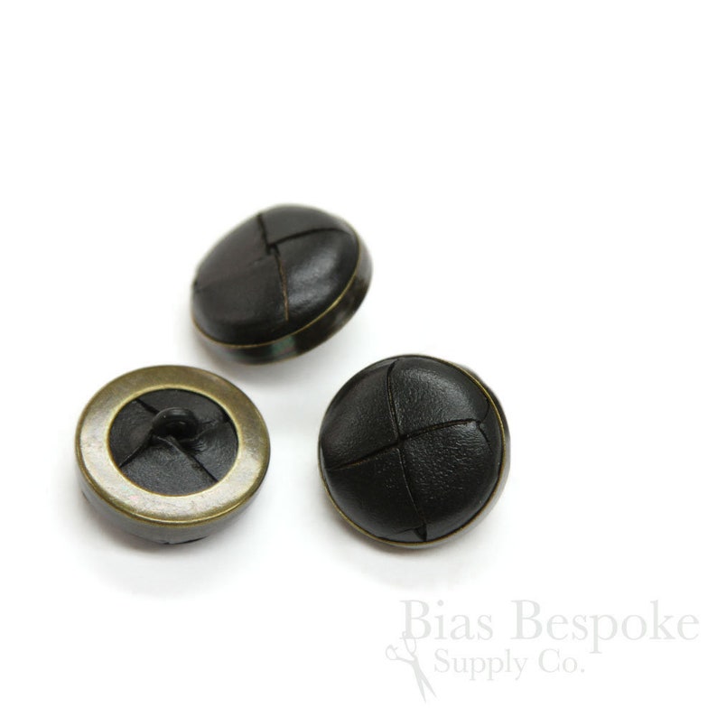 May include: Three black leather buttons with a cross-stitch design and antique gold metal trim.
