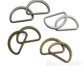 May include: Four sets of D-rings in three different finishes: silver, antique silver, and antique brass. Each set contains two D-rings.
