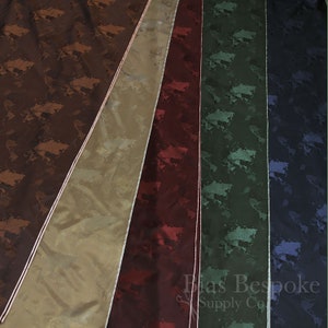 Könnte beinhalten: Nahaufnahme von sechs Stoffmustern mit einem Weltkartenmuster. Die Muster sind in verschiedenen Farben: Braun, Beige, Burgunderrot, Grün, Blau und Schwarz. Der Stoff hat einen dezenten Glanz.