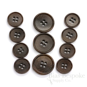 May include: Set of ten brown wood buttons, each with four holes. The buttons are arranged in three rows, with the largest button at the top and the smallest button at the bottom.