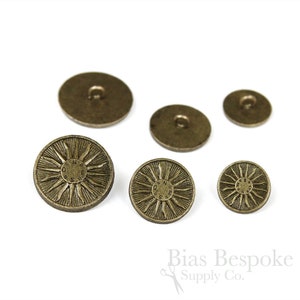 May include: Set of five antique gold metal buttons with a sunburst design and the words "Own The Sun" inscribed on the larger buttons.