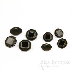 May include: A collection of antique brass buttons with an octagonal shape and a square center. The buttons have a decorative border and a loop on the back for sewing. Some buttons have a black or reflective center.