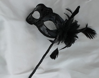 Stunning Black Masquerade Mask on a Black Stick with a flower made of black fabric petals, feathers and black and white organza