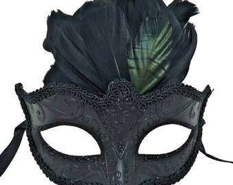 May include: A black masquerade mask featuring intricate embossed scrollwork patterns and a glittery finish. The mask is adorned with a cluster of dark black feathers at the top and is framed by a decorative braided trim along the eye openings.