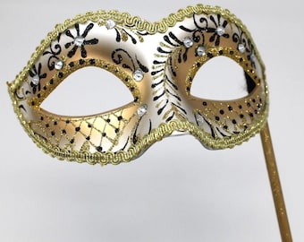 Glittering Black and Gold Masquerade Mask on a Gold Stick