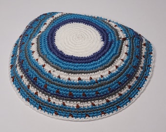 May include: A crocheted kippah with a white center and blue, gray, and brown stripes.